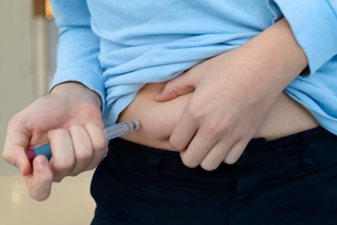 NAD injections for menopause showing a vial and syringe with a hormonal balance and wellness concept